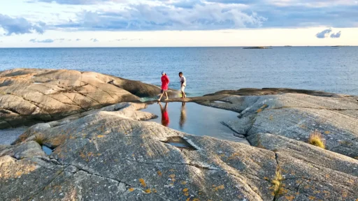 Promenerande människor på hällar i havsbandet