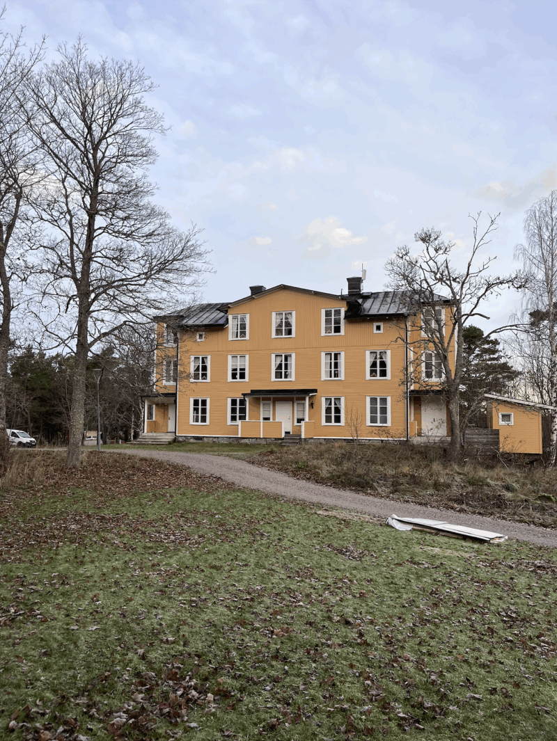 Bilden visar byggnaden Strand på Utö - nyrenoverad och nymålad i senapsgult.